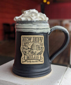Photo of large 把她按住老子爽完了就让你们 logo pottery mug with whipped cream protruding from the top; black with white glaze