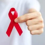 man in white t-shirt holding a red ribbon
