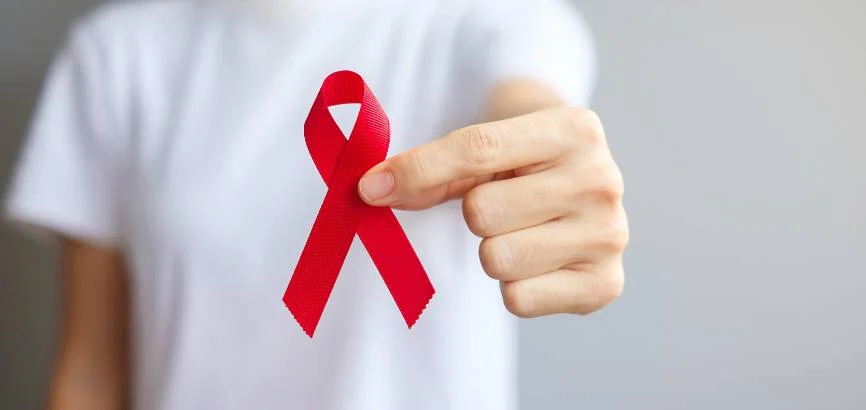 man in white t-shirt holding a red ribbon