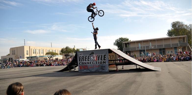 man on bike flying over another man