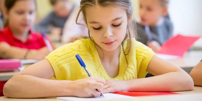 young girl writing in class