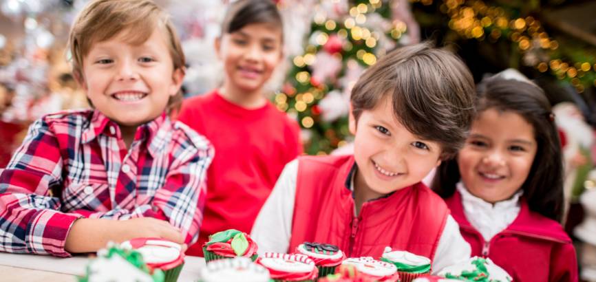 group of kids smiling around christmas decorations