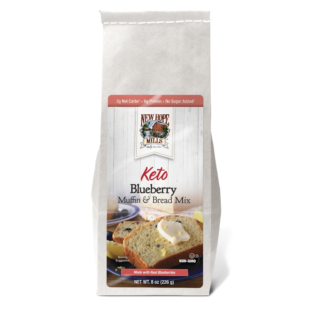 Front of the Keto Blueberry Muffin & Bread Mix, showing delicious looking bread with butter and blueberries on a plate.