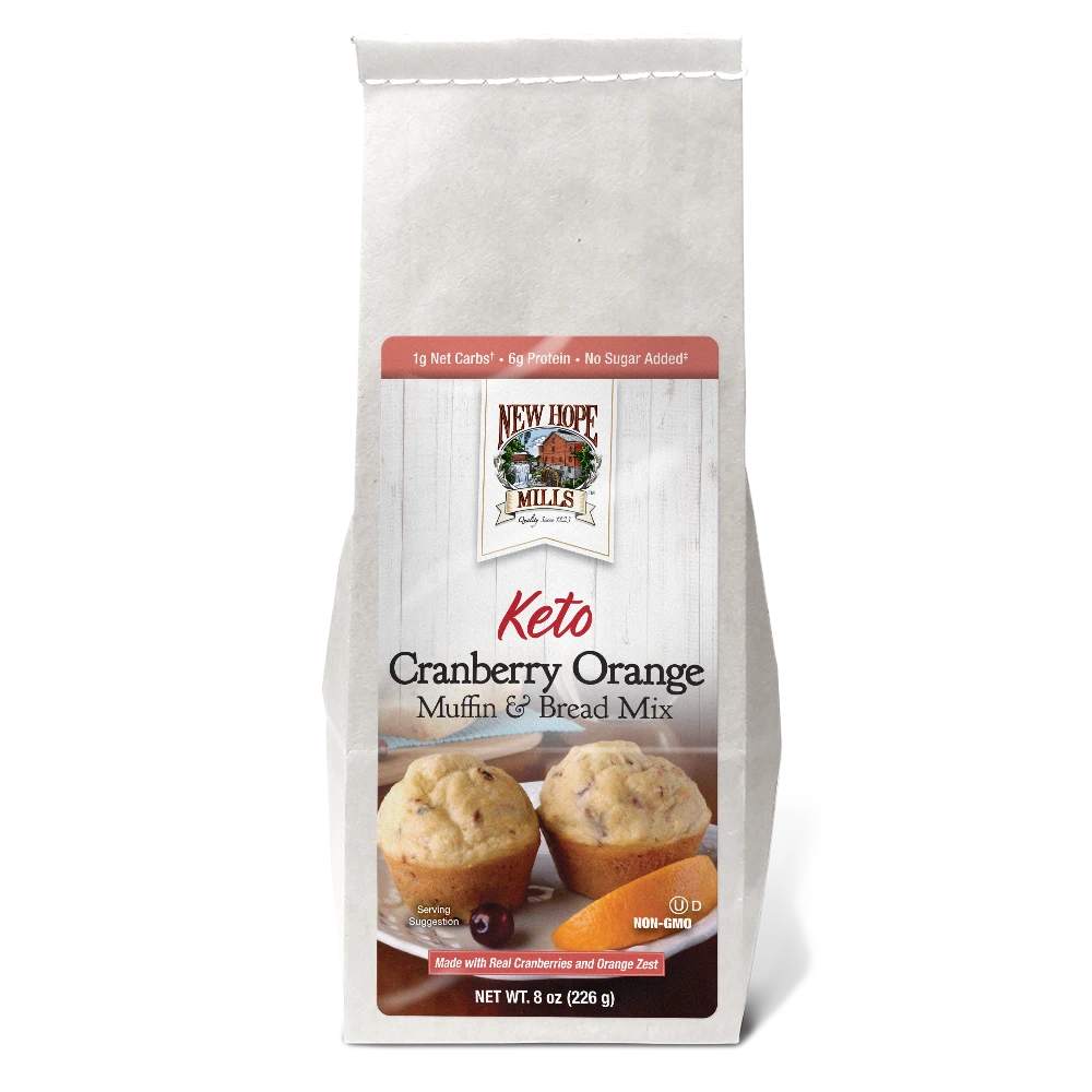 Front of the Keto Cranberry Orange Muffin & Bread Mix, showing delicious looking muffins with cranberries and an orange piece on a plate.